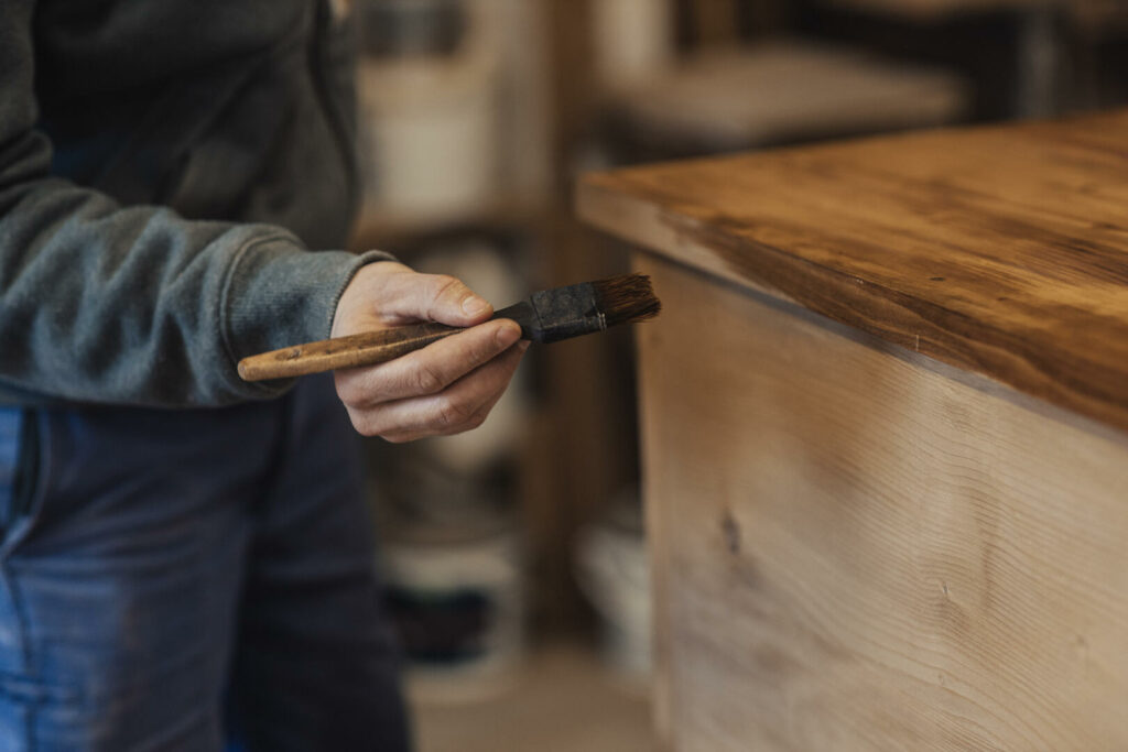 Dernier coup de vernis sur un meuble en bois