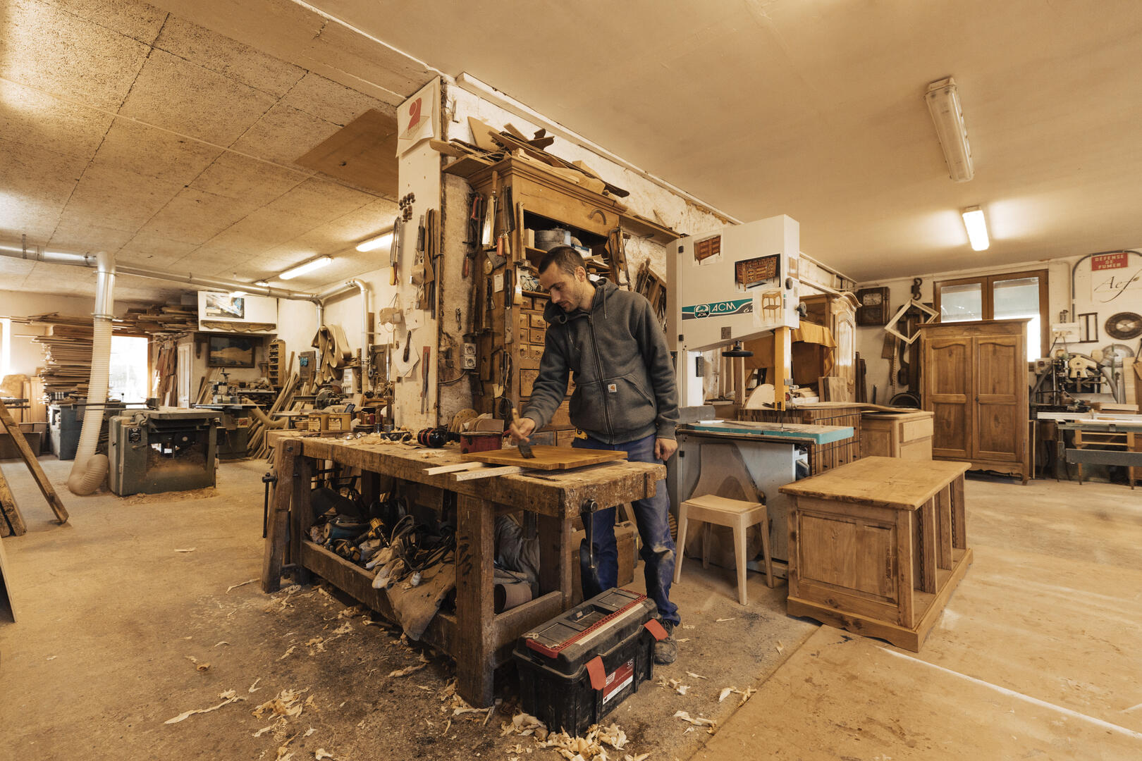 Ebéniste qui vernit une porte de placard dans atelier Jean-Pascal Bottiero